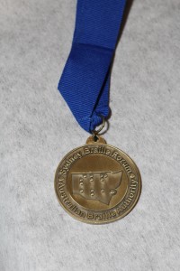 bronze medal with the the words "Sydney Braille Forum", "Australian Braille Authority" and a tactile map of NSW with "SBF", "ABA" in braille.