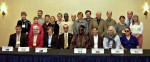 delegates seated and standing behind a table with the ICEB member country names