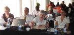 Australian delegates seated at a table. The Nigerian delegates and observers can be seen in the background.