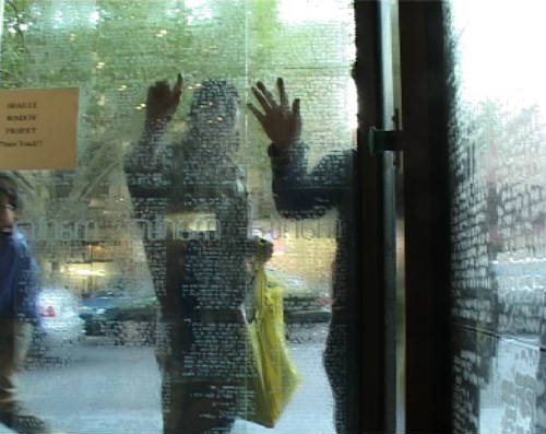 Two people touching glass windows covered in transparent braille